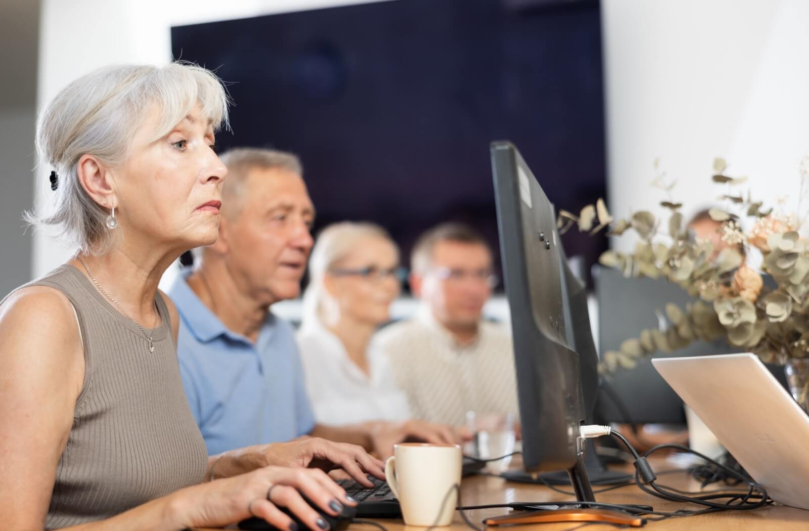 Older adults using computers in a personal care home, engaging with technology.