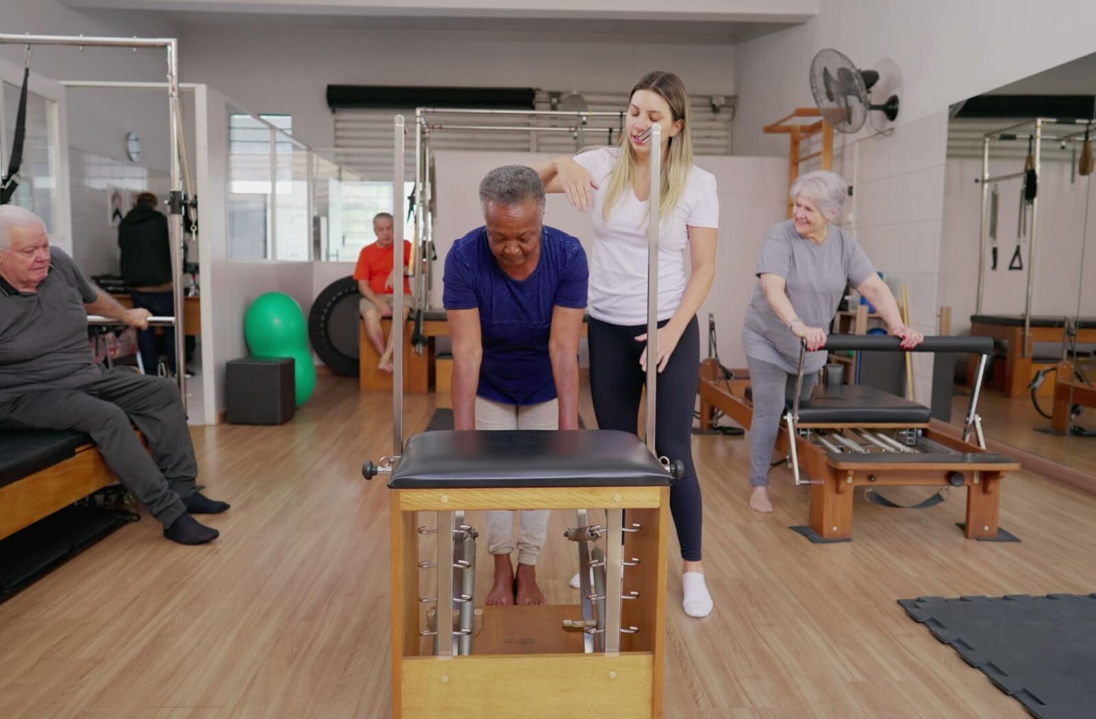 A group of older adults performing assisted balance exercises.