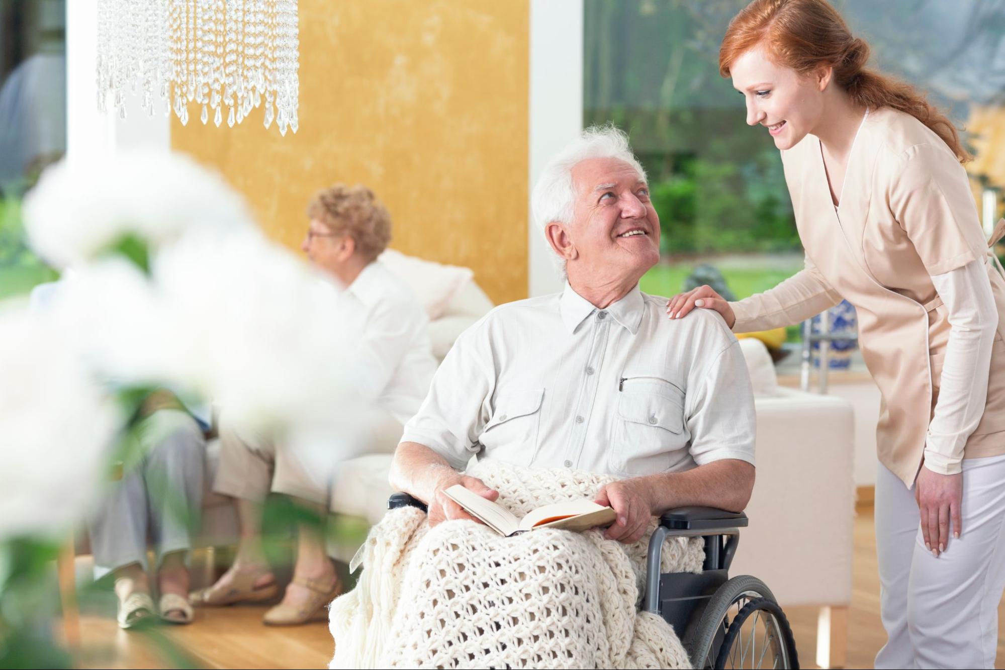 a caregiver checking on a senior with wheelchair in personal care