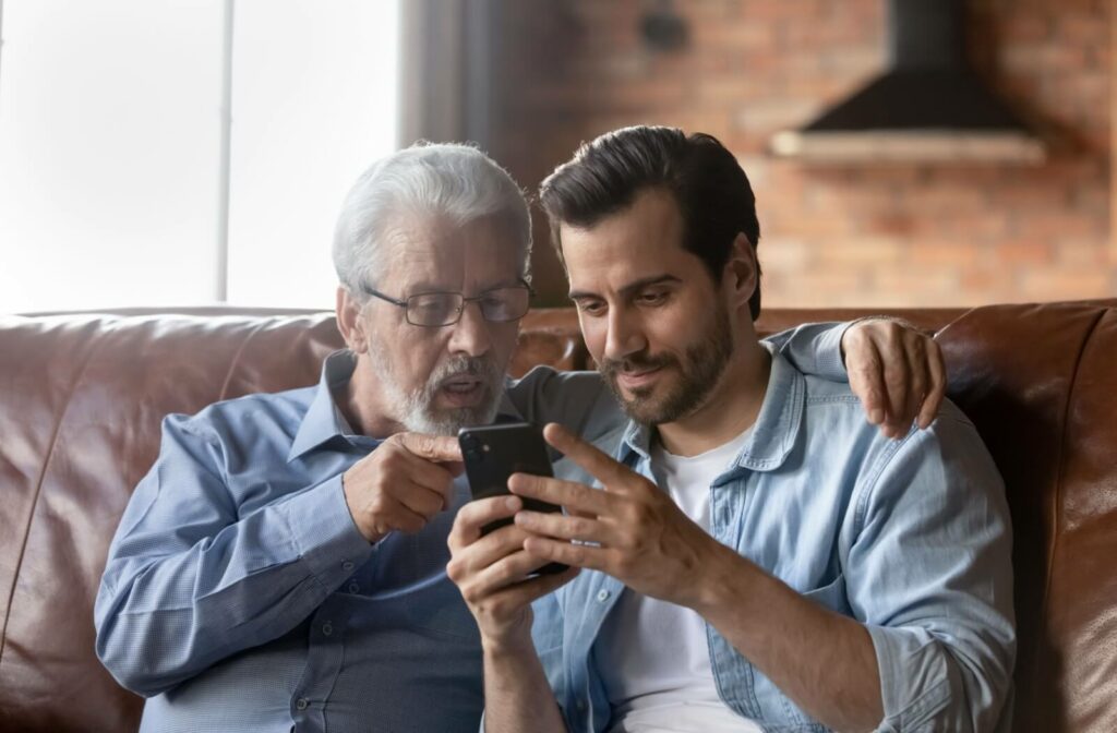 An adult uses their phone as a visual aid to improve communication between them and their older parent with dementia
